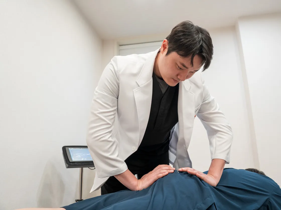 원장이 환자의 등에 침을 놓는 모습